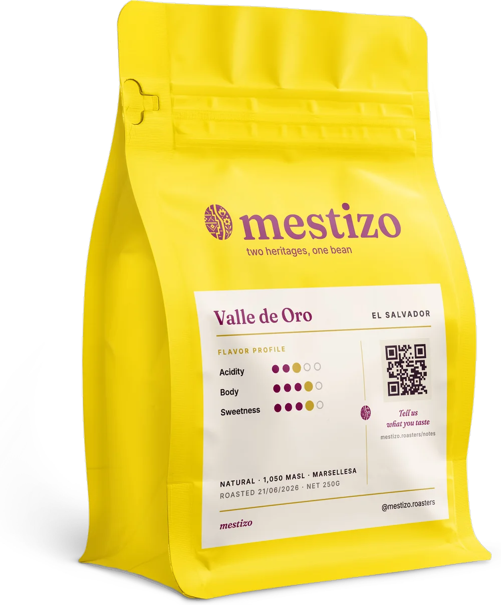 A bag of Mestizo Valle de Oro Natural — yellow pouch, purple lockup, cream back label.